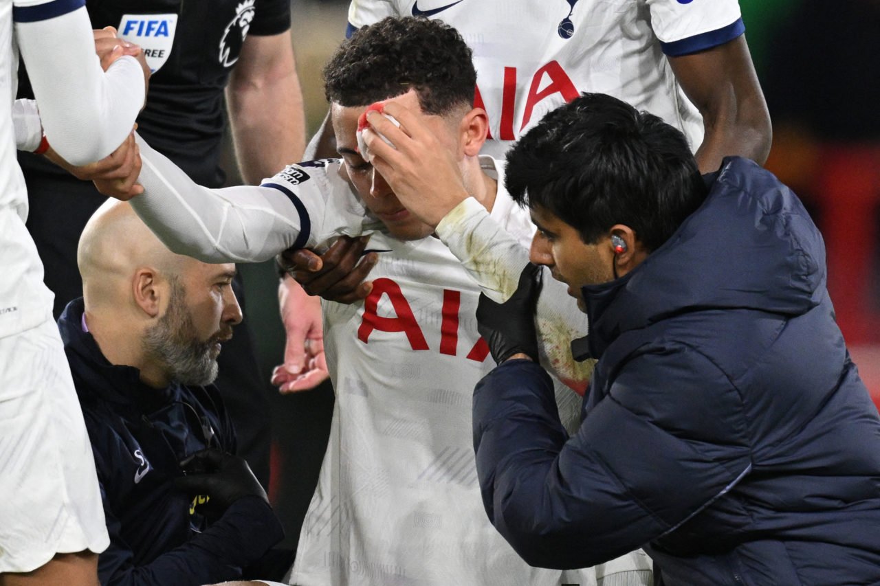Tottenham Hotspur's Welsh striker #22 Brennan Johnson (C) is helped up by medical staff after suffering a head injury during the English Premier Le...