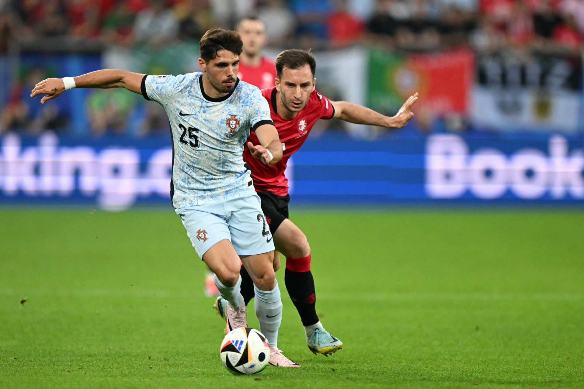 Portugal's midfielder #25 Pedro Neto runs with the ball chased by Georgia's defender #02 Otar Kakabadze during the UEFA Euro 2024 Group F football ...