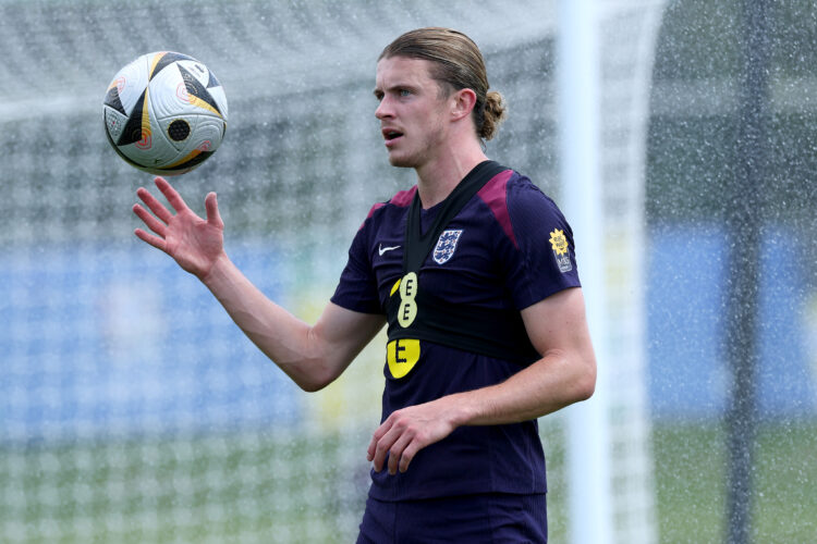 Conor Gallagher of England gets caught in a sprinkler during a training session at Spa & Golf Resort Weimarer Land on July 08, 2024 in Blankenh...